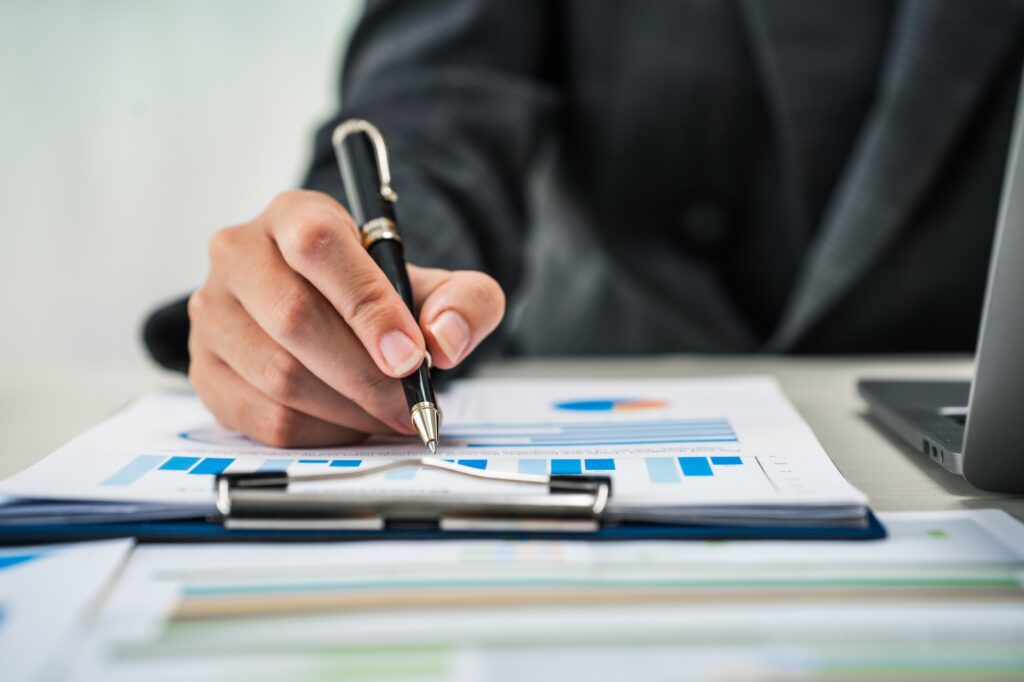 businesswoman works diligently at her desk, reviewing financial documents and analyzing investment