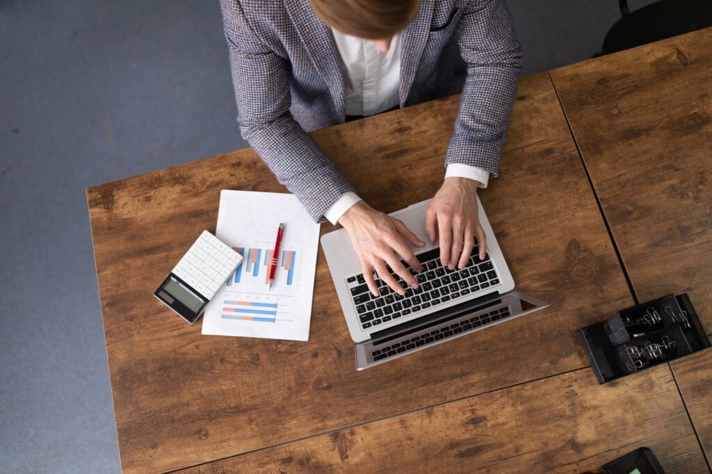 office man working in finance with charts and laptop