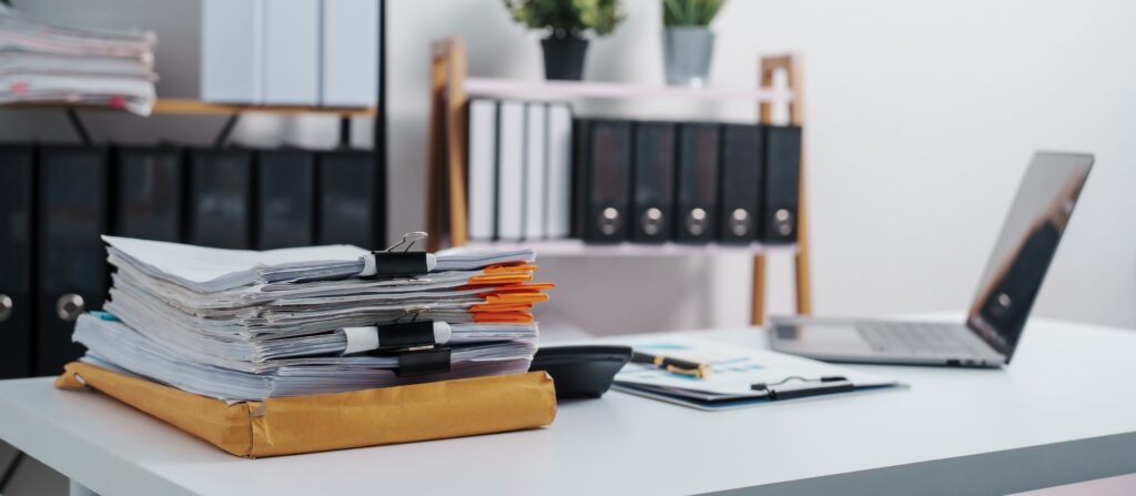 Stylish workspace with laptop, notebook, blank screen laptop on white table of bookkeeping.