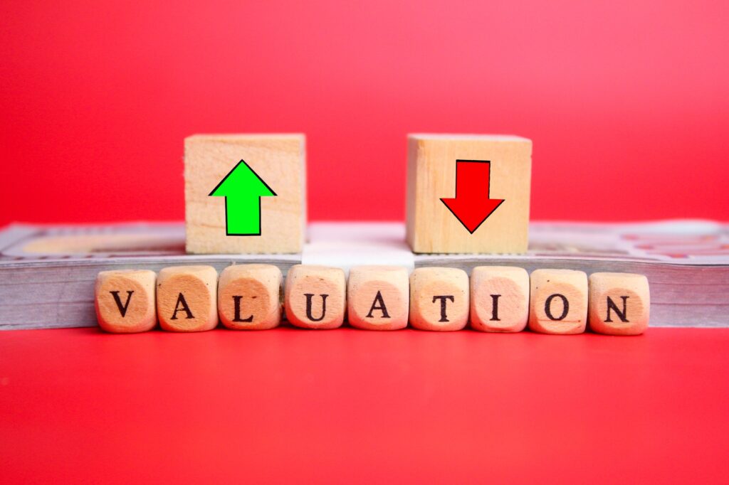 wooden cube with the word valuation and up and down arrows.